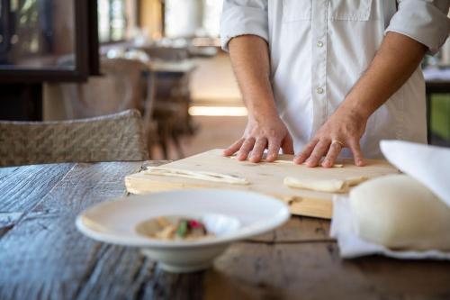 a chef preparing food on a wooden cutting board at Stazzo Lu Ciaccaru in Arzachena