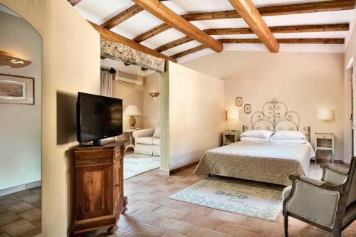 a bedroom with a bed and a flat screen tv at Stazzo Lu Ciaccaru in Arzachena