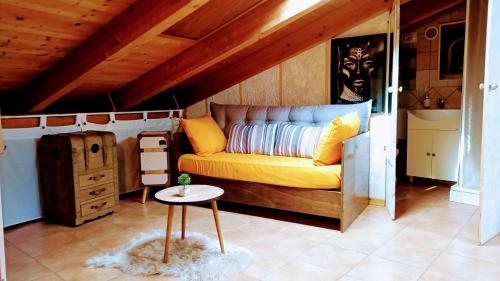 a living room with a yellow couch and a table at La casa di Maya in Sassari