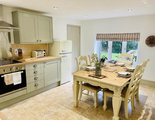 uma cozinha com uma mesa de madeira e uma sala de jantar em The Cottage, Yew Tree Farm Holidays, Tattenhall, Chester em Tattenhall
