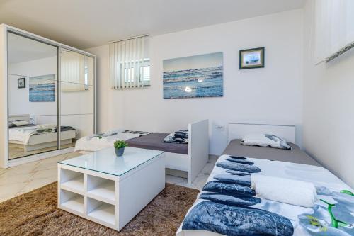 sypialnia z 2 łóżkami i stołem w obiekcie Apartments DIDO w Novalji