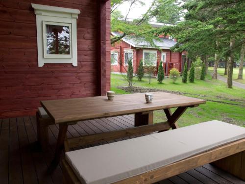 a wooden table and bench on the back of a house at The Prince Villa Karuizawa in Karuizawa
