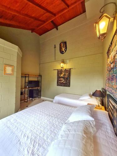 a bedroom with two white beds in a room at Pousada Camelot Inn in Alto Paraíso de Goiás