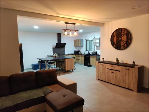 een woonkamer met een bank en een keuken bij Villa Ô Bel Air - 4 étoiles - détente au bord de la piscine et baby-foot ! in Saint-Joseph