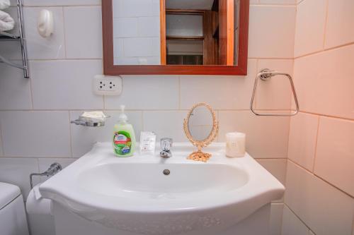 a bathroom with a white sink and a mirror at Cozy Room Cusco in Cusco
