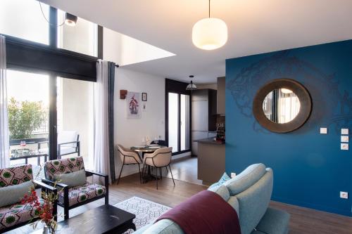 un salon avec un canapé et une salle à manger dans l'établissement Vill'Arborea - Magnifique T3 au coeur du 7ème, à Lyon