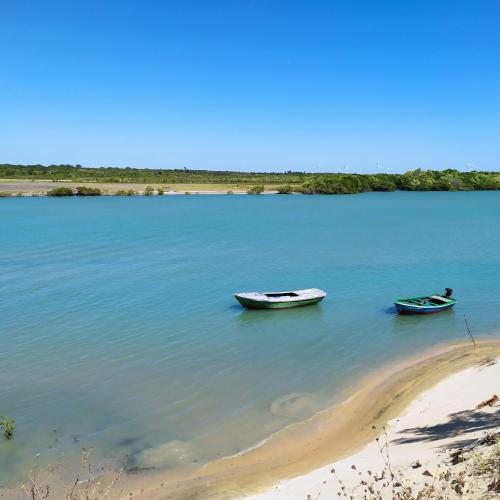 two boats sitting in the water next to a beach at Vila Samin Moitas in Praia de Moitas