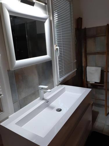 Chambre d'hote Casa Tozza في بورتيكيو: حمام مع حوض أبيض ومرآة