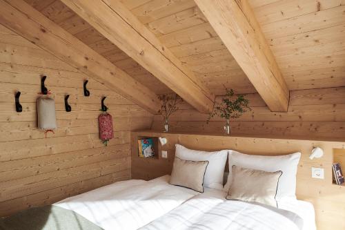 a bedroom with a bed in a wooden room at Carina - Design&Lifestyle hotel in Zermatt