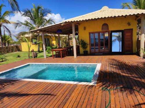una casa con piscina frente a una casa en Villa do Sossego - Caraíva, en Caraíva