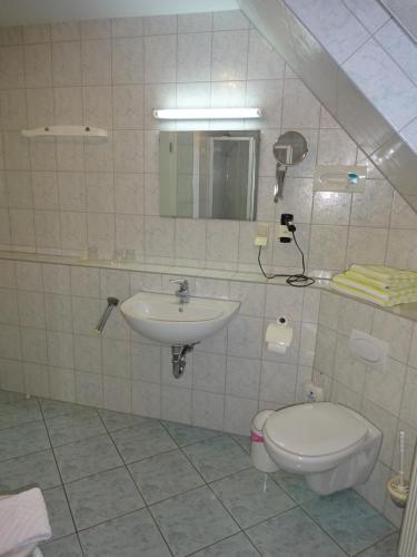 a bathroom with a sink and a toilet at Ferienwohnung Pension Sigwarth in Belgern