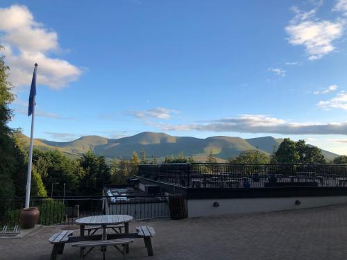 a picnic table with a flag and mountains in the background at Aherlow House Hotel & Lodges in Aherlow