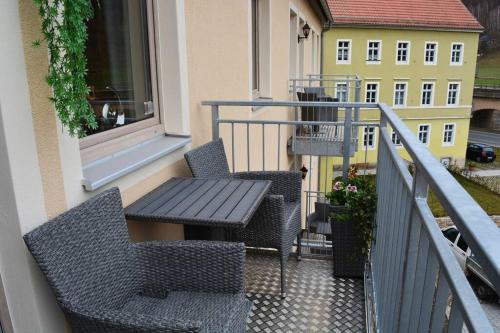 a balcony with two chairs and a table and a window at Elbtalblick Königstein im Deutschen Haus in Königstein an der Elbe