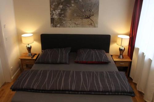 ein Schlafzimmer mit einem Bett mit zwei Lampen auf beiden Seiten in der Unterkunft Elbtalblick Königstein im Deutschen Haus in Königstein an der Elbe