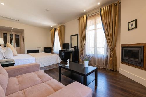 a hotel room with a bed and a couch at Nymfasia Resort in Vytina