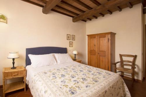 a bedroom with a bed and two tables and a chair at La Fattoria del Rio di Sopra - Agriturismo Baldeschi in Tuoro sul Trasimeno