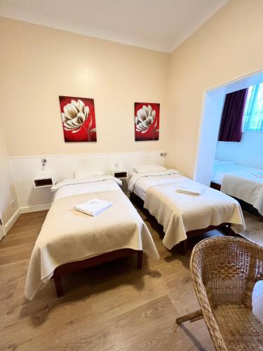 a room with three beds in a room at Melbourne House Hotel in London