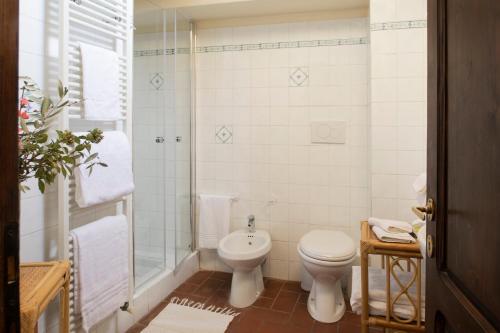 a white bathroom with a toilet and a shower at La Fattoria del Rio di Sopra - Agriturismo Baldeschi in Tuoro sul Trasimeno