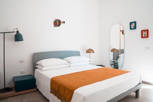ein Schlafzimmer mit einem großen Bett mit einer orangefarbenen Decke in der Unterkunft SIGNORA ANGELINA in Polignano a Mare