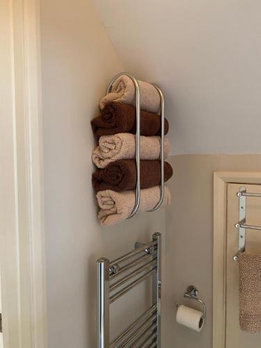 - un bouquet de serviettes suspendues au mur dans la salle de bains dans l'établissement Westdene, à Skegness