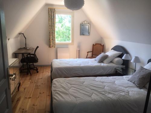 a bedroom with two beds and a desk and a window at La villa Le Petit Bois, près Rocamadour, Padirac in Lavergne
