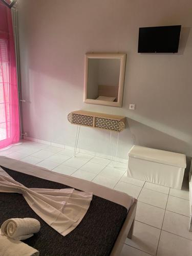 a white room with a mirror and a shelf at Petska Apartments in Leptokaria