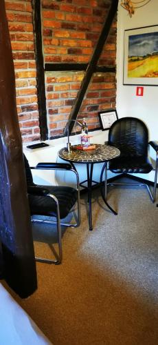 a table and chairs in a room with a brick wall at Pension Riverside in Leverkusen Hitdorf am Rhein - Zentral an der A1 und 59 in Leverkusen