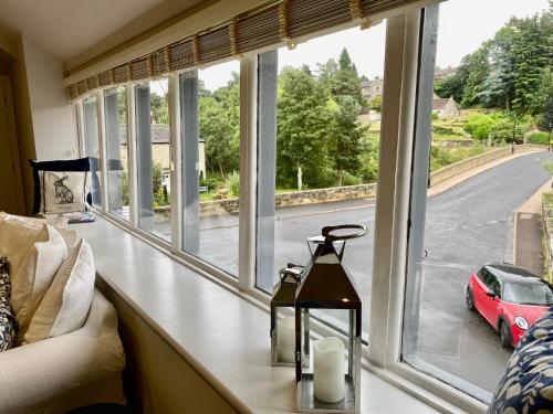 a window with a view of a red car in a street at No. 3 Tomlinsons Apartments in Rothbury