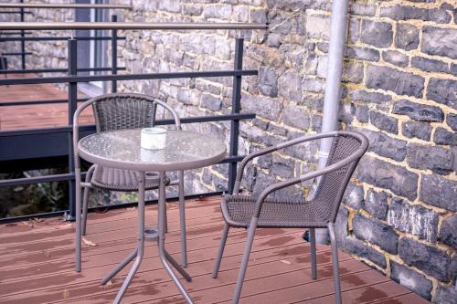 a table and two chairs on a balcony at Au bout de mes rêves in Walcourt