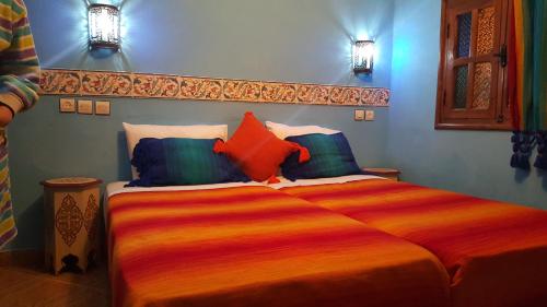 ein Schlafzimmer mit einem großen Bett mit bunten Kissen in der Unterkunft Gite Talassemtane in Chefchaouen