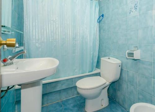 uma casa de banho azul com um WC e um lavatório em BENIDORM GEMELOS II ONE, impresionante vista em Benidorm