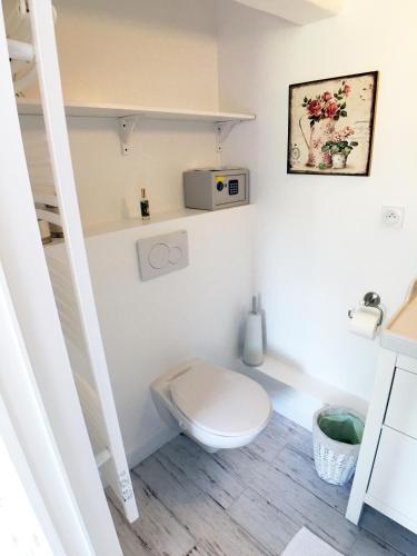 a small bathroom with a toilet and a sink at La Romance et la Romanesque in Berville-sur-Mer