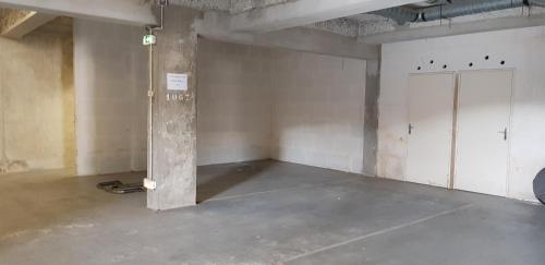 an empty room with a concrete floor and a door at ARCACHON PETIT PORT - T3 VUE BASSIN in Arcachon