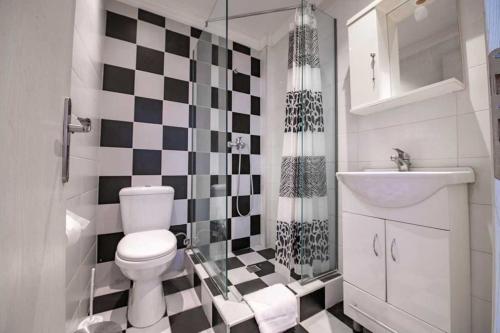 a bathroom with a black and white checkered floor at Kanoni Garden Studio in Kanoni