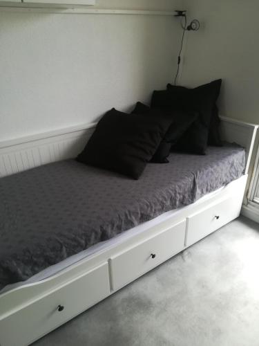 - un lit avec des oreillers noirs dans l'établissement Studio la grande motte, parking, à La Grande Motte