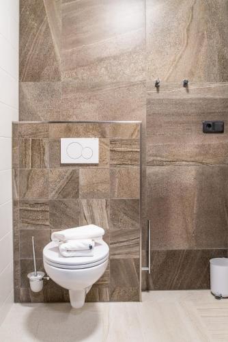 a bathroom with a toilet and a stone wall at Chata Krušnohorka in Kovářská