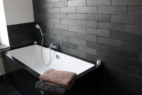 a bathroom with a white tub with a towel on it at Peter House in Nivelles
