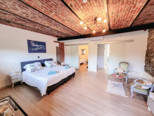 a bedroom with a bed and a brick ceiling at Au bout de mes rêves in Walcourt