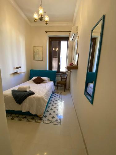 a bedroom with a blue bed and a mirror at IL PALAZZO - Luxury Home & Event in Cosenza