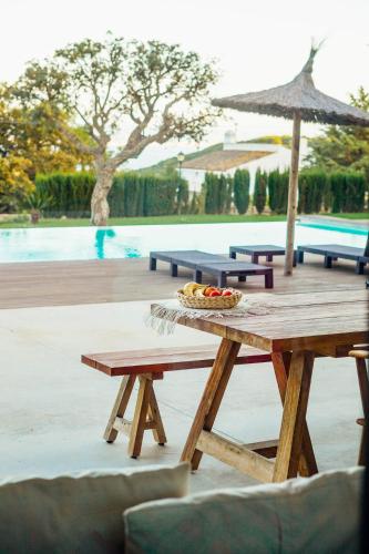 a picnic table with a bowl of fruit on it next to a pool at CASA DOS MARES in Tarifa