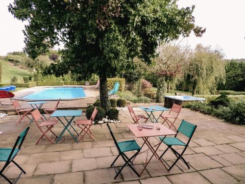 a group of tables and chairs next to a pool at Au bout de mes rêves in Walcourt