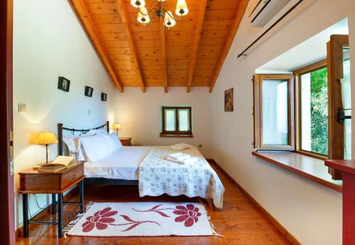 a bedroom with a bed and a desk and windows at Villa Elia, ,Platanos, Paxos in Koútsion