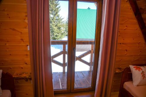 a door to a porch with a view of a deck at Ville Uskoci in Žabljak