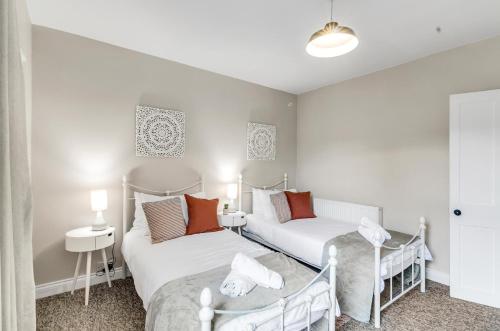 two beds in a small room with two lamps at 2BR Cosy Stay Near Cathedral Parking Workspace in Norwich