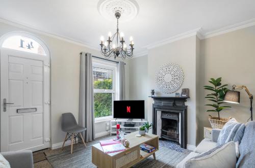 a living room with a tv and a fireplace at 2BR Cosy Stay Near Cathedral Parking Workspace in Norwich