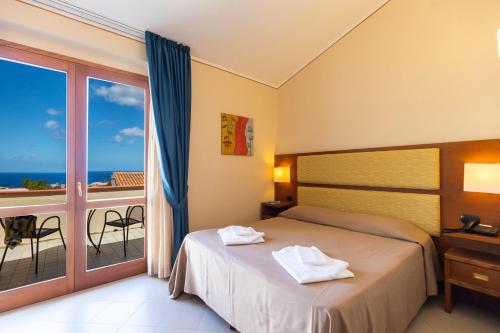 a hotel room with a bed and a balcony at Hotel Tropis in Tropea