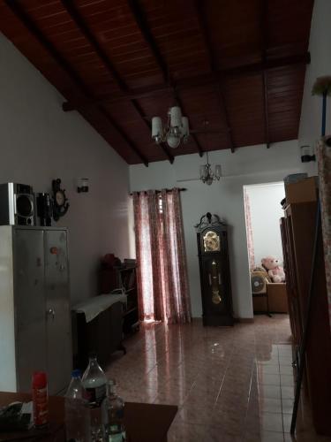 a living room with a clock in the corner of a room at RAJASINGHE Guest in Kaduwela