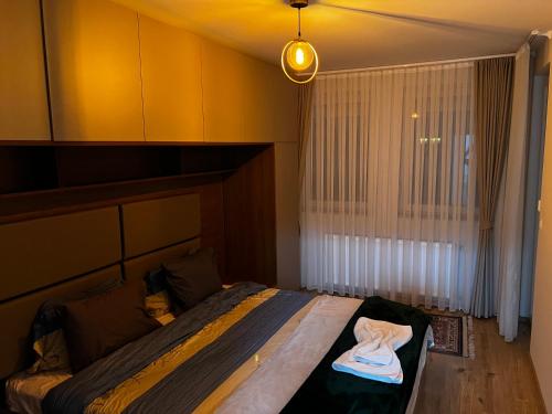 a bedroom with a bed in a room with a window at Elegant Apartment in City Centre in Pristina