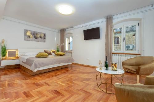 Un dormitorio con una cama y una mesa y sillas. en Deluxe Dreamy room in the Center of Hvar with Sea View, en Hvar