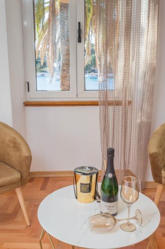 Una mesa con una botella de vino y dos copas. en Deluxe Dreamy room in the Center of Hvar with Sea View, en Hvar